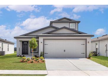 Charming single-Gathering home with a two-car garage, manicured lawn, and modern architectural details at 124 Hallam Ct, Spring Hill, FL 34606