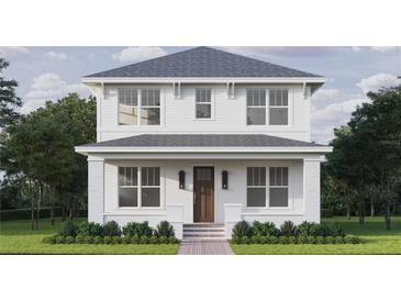 Charming two-story home featuring a classic white exterior, inviting front porch, and beautifully manicured landscaping at 1521 21St N Ave, St Petersburg, FL 33704