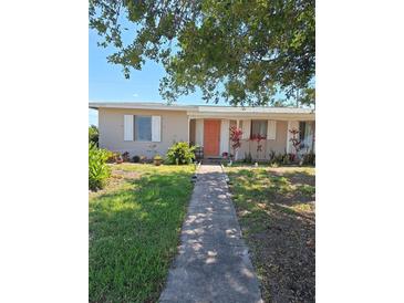 Charming single-story home with a well-manicured lawn and inviting walkway to the front door at 361 Fairhaven St, Port Charlotte, FL 33952