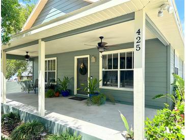 Charming home exterior featuring a spacious front porch with ceiling fans and lovely landscaping at 425 E Orange St, Tarpon Springs, FL 34689