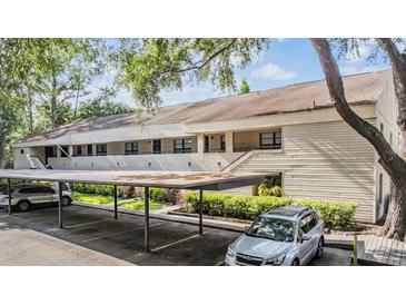 Inviting exterior shot of a condo building with covered parking and well-maintained landscaping at 4917 Puritan Cir # 105, Tampa, FL 33617