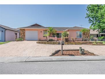 Charming single-story home featuring a brick driveway, lovely stone accents, and manicured landscaping at 7812 Turnbridge Dr, Port Richey, FL 34668