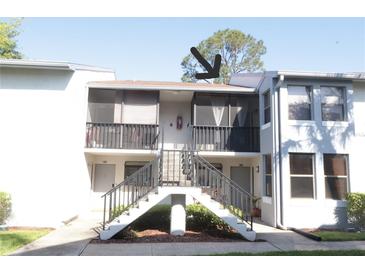 Two-story condo building with dual staircases leading to screened second-story porches at 2024 Blue Hawk Ct # 1822, Clearwater, FL 33762