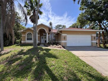 Charming single-story home featuring a well-manicured lawn, arched entryway, and attached two-car garage at 2752 Cypress Dr, Clearwater, FL 33763