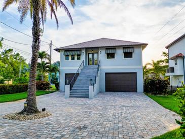 Two-story home featuring a paved driveway, two car garage, palm tree and stairway to front door at 3924 N Ridge Ave, Tampa, FL 33603