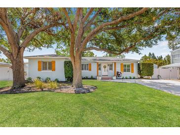 Charming single-story home features a well-manicured lawn, mature trees, and decorative shutters at 4920 17Th N Ave, St Petersburg, FL 33710