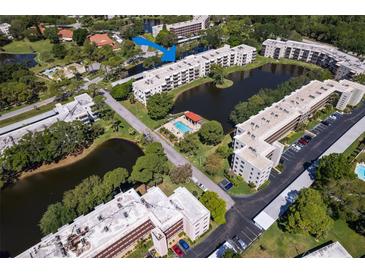 An inviting aerial view of a condo complex with a lake, pool, and lush landscaping at 6070 80Th N St # 308, St Petersburg, FL 33709