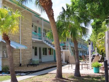 Beautiful condo building with tropical landscaping and inviting outdoor seating area at 6100 21St N St # 17, St Petersburg, FL 33714