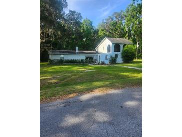 Charming home featuring stone accents, stucco exterior, and lush landscaping, set against a backdrop of mature trees at 9481 Patrick St, Brooksville, FL 34601