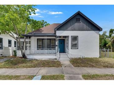 Charming home with a inviting front porch, complemented by a blue front door at 1208 E 18Th Ave, Tampa, FL 33605