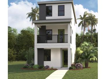 Modern three-story home featuring a stucco exterior, dark accents, a front porch, and a well-manicured lawn at 2311 W Spruce St, Tampa, FL 33607