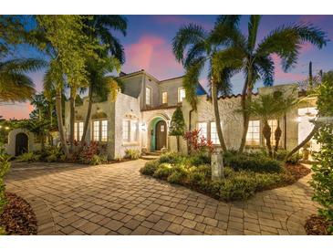 Elegant two-story home featuring lush landscaping, a cobblestone driveway, and a stucco facade at 356 22Nd Ne Ave, St Petersburg, FL 33704