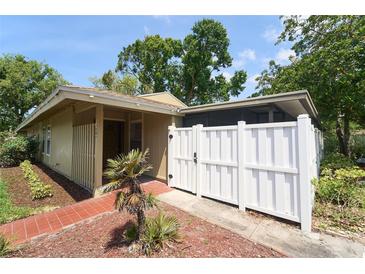 Inviting home featuring a private white-fenced courtyard and lush landscaping around the house at 7205 San Luis Ct, Tampa, FL 33634