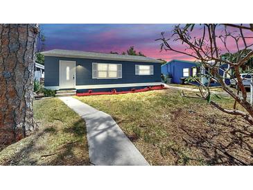 Charming single-story home featuring a blue exterior, white trim, and well-maintained landscaping at 1402 Freemont S St, Gulfport, FL 33707