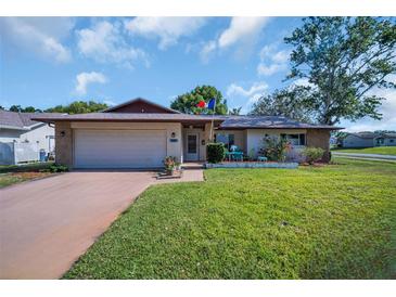 Charming single-story home featuring a two-car garage and a well-maintained front yard at 2967 Macalpin N Dr, Palm Harbor, FL 34684