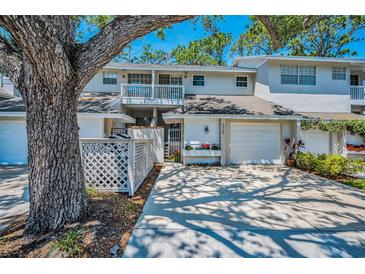 Inviting townhouse featuring a well-manicured lawn, attached garage, and lovely curb appeal, perfect for relaxed living at 5115 S Jules Verne Ct, Tampa, FL 33611