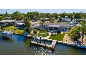 Waterfront home featuring a private dock and boat lift and manicured landscaping at 9301 Sun Isle Ne Dr, St Petersburg, FL 33702