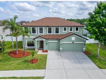 Spacious home with a three-car garage, a well-manicured lawn and beautiful landscaping at 11804 Harpswell Dr, Riverview, FL 33579