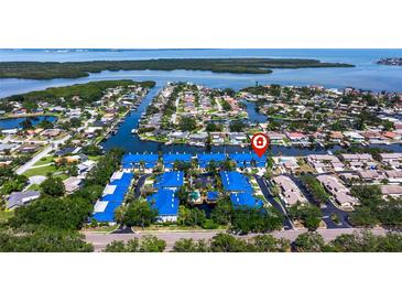 An overhead shot showcases the neighborhood and a building with a blue roof near the ocean at 1625 Watermark Ne Cir, St Petersburg, FL 33702
