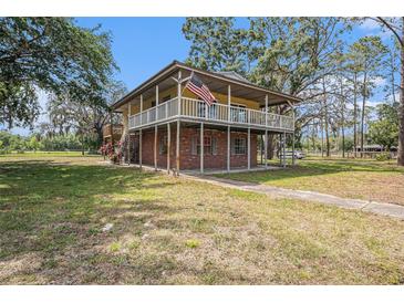 Charming two-story home with a wraparound porch and brick foundation at 18838 Huckavalle Rd, Odessa, FL 33556
