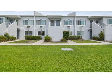 Two-story condo building featuring a well-maintained lawn and simple, clean architectural details at 4141 Dolphin Dr # 4141, Tampa, FL 33617
