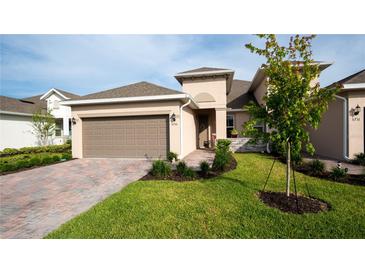 Charming single-story home featuring a paver driveway, two-car garage, and well-manicured landscaping at 5735 Mezzana Run, Palmetto, FL 34221