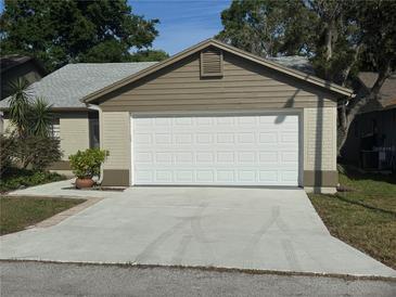 Attached one-car garage featuring a white door and concrete driveway at 7941 Clarendon Dr, New Port Richey, FL 34654