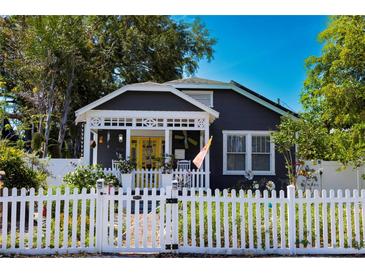 Charming home with a bright yellow door and a white picket fence creating a welcoming curb appeal at 1036 23Rd N Ave, St Petersburg, FL 33704