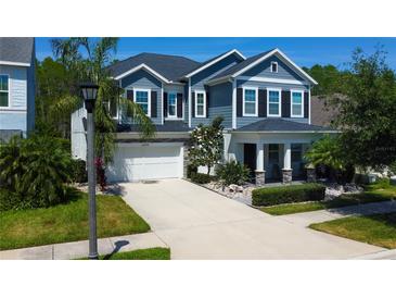Beautiful two-story home with a manicured lawn, a two car garage, and elegant landscaping at 14975 Renaissance Ave, Odessa, FL 33556