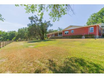Sprawling brick ranch-style home with large yard and mature trees creates a peaceful and private setting at 34211 Blanton Rd, Dade City, FL 33523