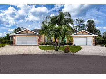 Charming single-story home featuring a well-manicured lawn, a circular driveway, and a symmetrical design at 542 Princeton Greens Ct # 21, Sun City Center, FL 33573