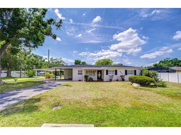 Charming single-story home features a well-manicured lawn and welcoming carport, with traditional shutters at 6612 N Orleans Ave, Tampa, FL 33604
