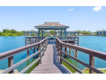 Water view of dock with seating area on a sunny day surrounded by trees and blue water at 11485 Oakhurst Rd # 312, Largo, FL 33774