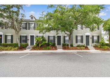 Charming townhome with neutral siding, black shutters, and manicured landscaping, offering curb appeal at 11541 Fountainhead Dr, Tampa, FL 33626
