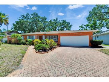 Charming single-story home with a well-manicured front yard and a brick-paved driveway leading to a two-car garage at 2505 E 19Th Ave, Tampa, FL 33605