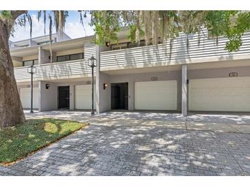 Condominium exterior featuring individual garages and an inviting facade with mature landscaping at 301 2Nd N St # 13, St Petersburg, FL 33701