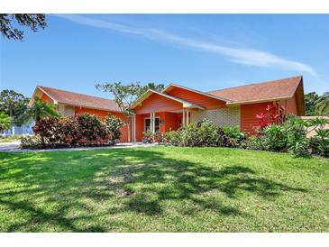 Charming single-story home with colorful landscaping and a well-maintained lawn at 3122 Lake Valencia E Ln, Palm Harbor, FL 34684