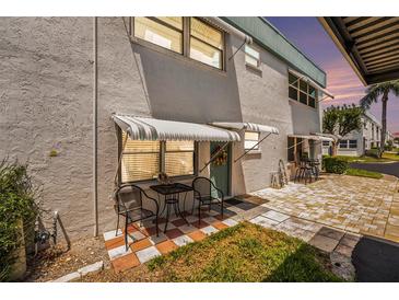 Condo exterior showcasing a quaint patio area with seating and colorful surroundings at 5216 81St N St # 2, St Petersburg, FL 33709
