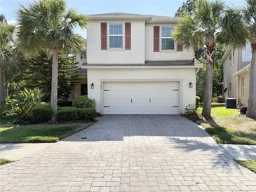 Charming two-story home with a two car garage, paver driveway, and lush tropical landscaping at 7704 Tuscany Woods Dr, Tampa, FL 33647