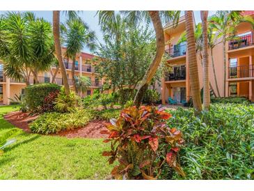 Inviting peach condos with black balcony railings surrounded by lush tropical landscaping at 8931 Blind Pass Rd # 257, St Pete Beach, FL 33706
