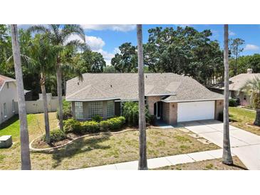Charming single-story home with lush landscaping, brick accents, and a two-car garage at 9730 Reynosa Dr, New Port Richey, FL 34655