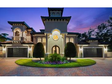 Elegant home featuring a barrel tile roof, manicured landscaping, circular driveway, and a grand entrance at 1600 Magnolia Rd, Belleair, FL 33756