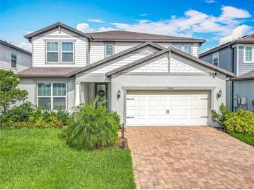 Charming two-story home with well-maintained landscaping and a brick paver driveway at 17683 Ramble On Way, Land O Lakes, FL 34638