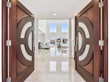 Grand entryway featuring custom double doors and a view into a spacious living area with water views at 2233 Donato Dr, Belleair Beach, FL 33786