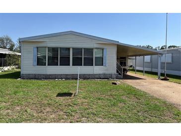 Charming single-story home with a covered carport and well-maintained lawn at 35804 Brisa Dr, Zephyrhills, FL 33541