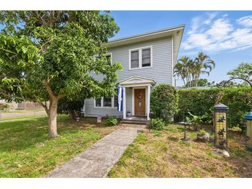 Charming home featuring a well-manicured lawn, sidewalk, mature trees, and a welcoming front door at 4100 1St S Ave, St Petersburg, FL 33711