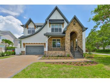 Beautiful two-story home with a stone facade, arched entryway, and well-manicured lawn at 4224 W Corona St, Tampa, FL 33629