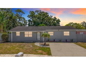 Charming single-story home with fresh gray paint and a well-manicured front yard and a large driveway at 8345 81St Ct, Seminole, FL 33777
