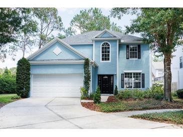 Charming blue two-story home featuring a two-car garage and well-maintained front landscaping at 17734 Long Ridge Rd, Tampa, FL 33647