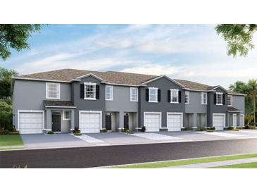 Newly constructed townhomes feature two-car garages, neutral paint, and nicely landscaped yard at 32429 Welling Blade Loop, Wesley Chapel, FL 33545